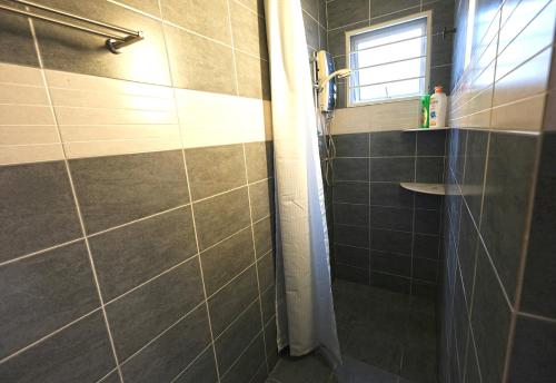 een badkamer met een douche en een raam bij Fivehouz Guest House in Petaling Jaya