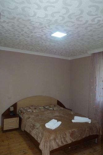 a bedroom with a bed with two towels on it at Sunny guesthouse in Stepantsminda