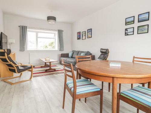 a living room with a table and chairs and a couch at Swanage Bay Apartment in Swanage