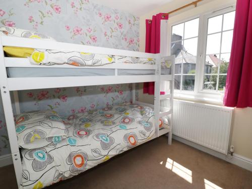 a bedroom with two bunk beds in a room at West Shore Cottage in Llandudno