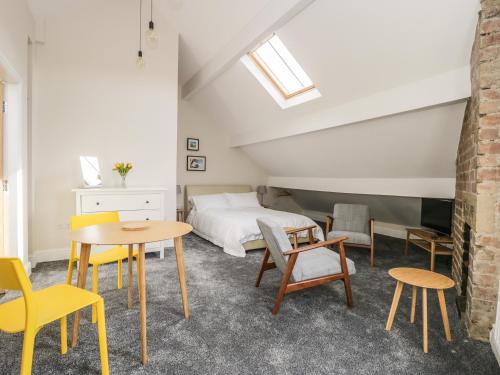 a bedroom with a bed and a table and chairs at The Attic in Keighley
