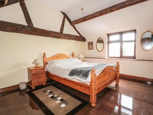 a bedroom with a wooden bed and a window at The Courtyard in Kington