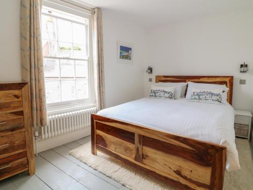 a bedroom with a large bed and a window at Sunny Cottage in Torpoint