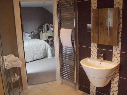 a bathroom with a sink and a bedroom at Causeway Lodge in Bushmills