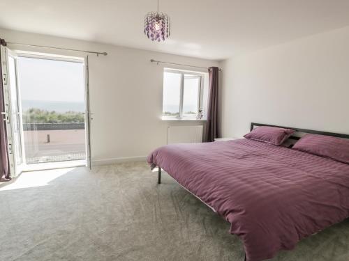a bedroom with a bed and a large window at Welymora in Pwllheli