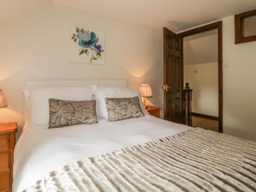 ein Schlafzimmer mit einem weißen Bett und zwei Kissen in der Unterkunft Woodhead Farm Cottage in Penrith