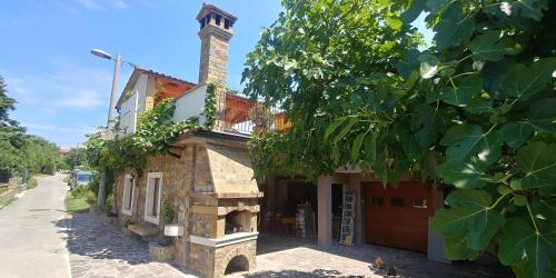 a building with a chimney on the side of it at Kmetija Jogan, Wines & Apartments in Pobegi