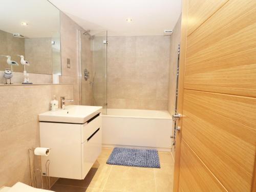 a bathroom with a tub and a sink and a shower at 7 Ocean Gateway in Hythe