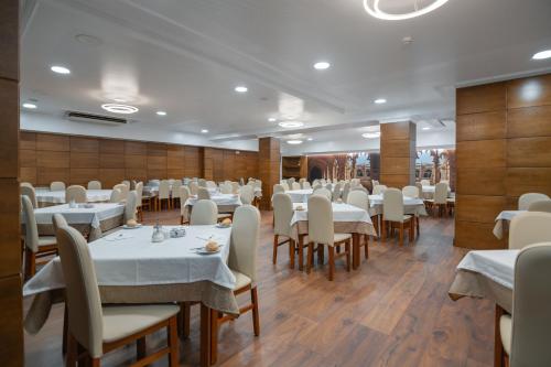 a restaurant with white tables and chairs and wooden walls at Avenida de Fatima in Fátima