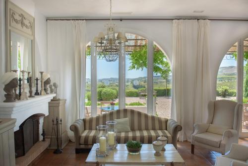 a living room with a fireplace and a chandelier at B Bou Hotel Cortijo Bravo in Vélez-Málaga