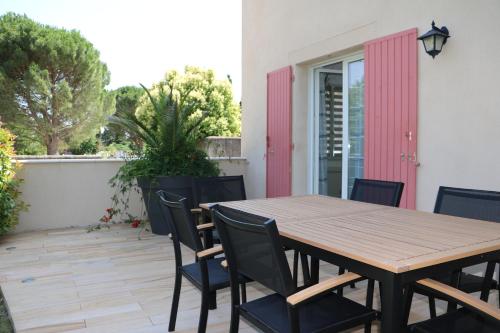 une table et des chaises en bois sur une terrasse dans l'établissement Charmante maison de village, à Cucuron