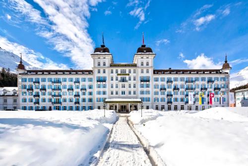 a large building with snow in front of it at Grand Hotel des Bains Kempinski in St. Moritz