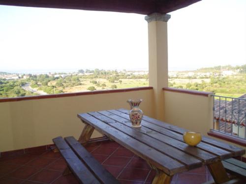 a wooden table with a vase on top of a balcony at Lulamax Sardegna in Budoni