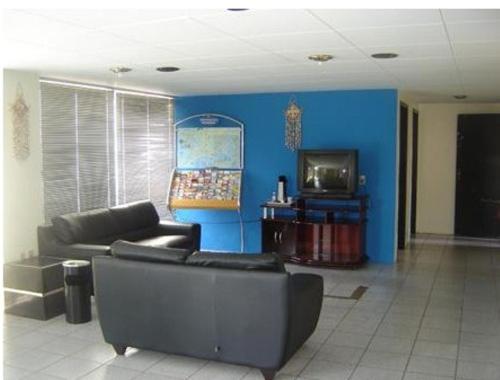 a living room with a couch and a tv at Rede Andrade Porto Mar in Maceió