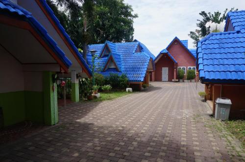 a row of houses with blue roofs on a street at 58 Ville Resort in Bangkok