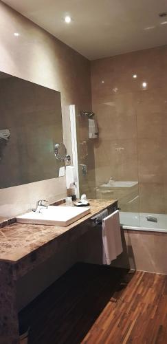 a bathroom with a sink and a mirror and a shower at Hotel Restaurante El Valles 4 ESTRELLAS in Briviesca