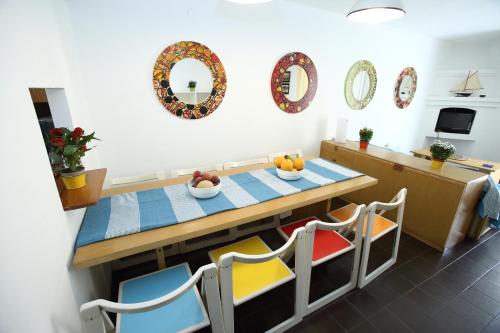 Casa Arcobaleno Carloforte في كارلوفورتي: مطبخ مع طاولة وكراسي عليها فاكهة