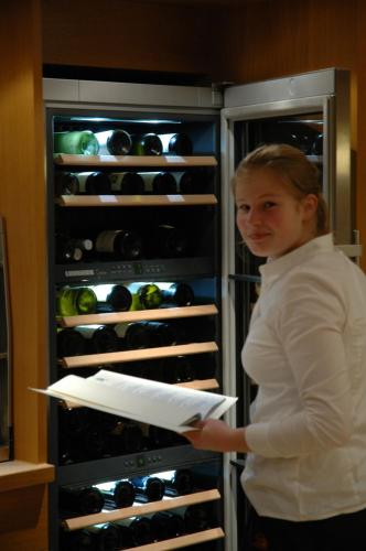 a woman is standing in front of an open refrigerator at Hotel Gasthof Engel in Appenweier