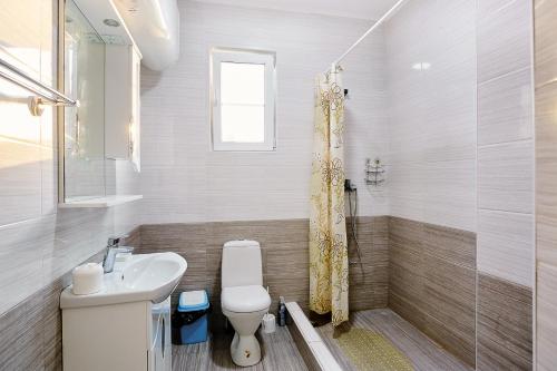 y baño con aseo, lavabo y ducha. en Hotel Solntse Abkhazii, en Pitsunda