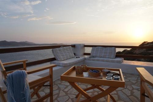 a balcony with a table and chairs and the ocean at Antiparos Vibes in Agios Georgios