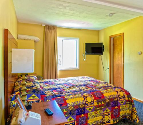 a hotel room with a bed with a colorful blanket at Parker's Motel in Lincoln
