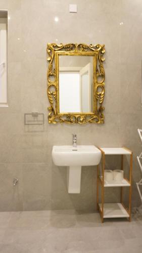a bathroom with a sink and a mirror on the wall at Ivory Suite Valletta in Valletta