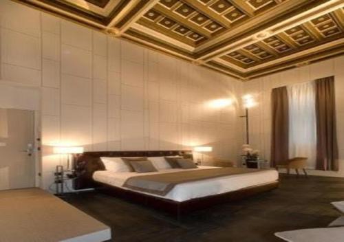 a hotel room with a large bed and a large window at Piazza Del Gesu' Luxury Suites in Rome