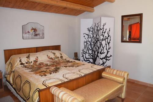 Dormitorio con cama con banco en Casa il Carrubbo, en Frigintini