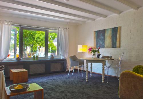 - un salon avec une table et une fenêtre dans l'établissement Het Huis tussen Kerk en Klooster, à Ootmarsum