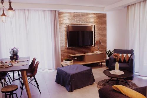 a living room with a television on a brick wall at Apartamenty Magnum in Szklarska Poręba