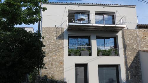 a white house with a balcony on top of it at Le Castellas du Pic St Loup in Saint-Mathieu-de-Tréviers