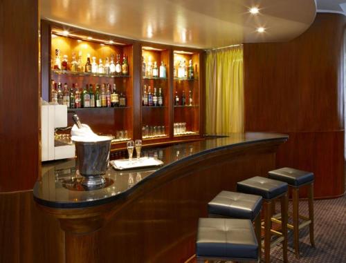 a bar with stools in a room with alcohol at LH Hotel Sirio Venice in Mestre