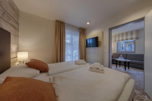 a bedroom with a large bed with towels on it at Aquamaris Strandresidenz Rügen in Juliusruh
