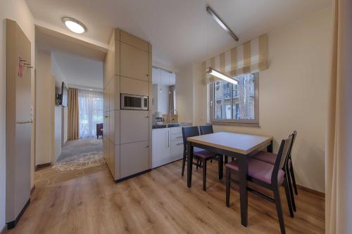 a kitchen and dining room with a table and chairs at Aquamaris Strandresidenz Rügen in Juliusruh