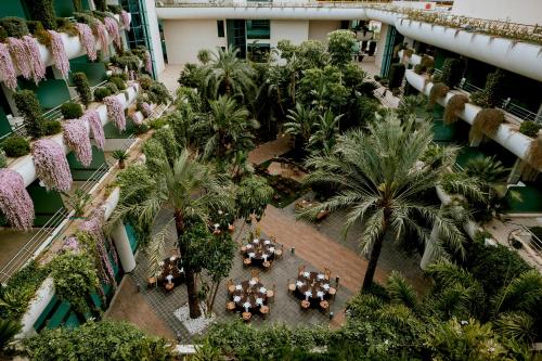 an overhead view of a building with tables and palm trees at Hotel Deloix 4* Sup in Benidorm