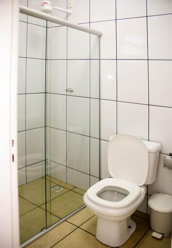 a bathroom with a toilet and a glass shower at Chales do Velho Chico in Três Marias