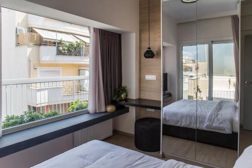 1 dormitorio con balcón con cama y ventana en Athens Luxury, en Atenas