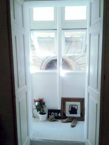 a window in a room with a clock and a plant at townhouse cospicua , ( 3 cities-valletta ) ferry in Cospicua