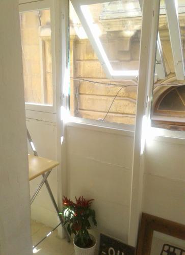 a window in a room with a plant next to it at townhouse cospicua , ( 3 cities-valletta ) ferry in Cospicua
