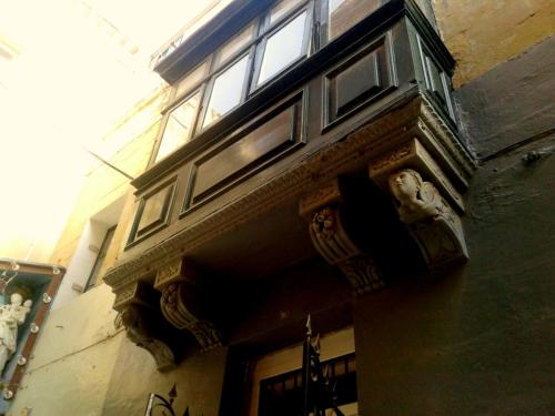 a building with windows on the side of it at townhouse cospicua , ( 3 cities-valletta ) ferry in Cospicua