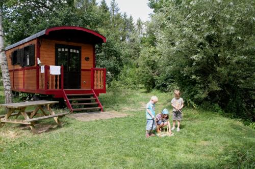 a group of people standing in the grass near a tiny house at La Maison de l'Omignon in Vermand