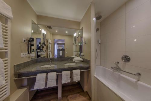 a bathroom with two sinks and a large mirror at Aquamaris Strandresidenz Rügen in Juliusruh