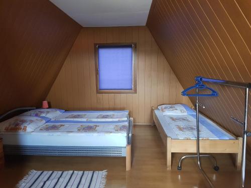 a attic room with two beds and a window at Casutele Intim in Costinesti