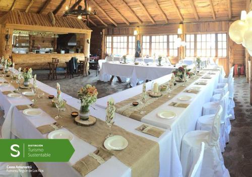 a large banquet hall with white tables and chairs at Cabañas Amunantu in Futrono