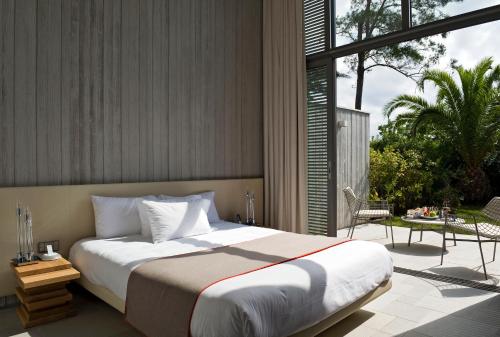 a bedroom with a large bed and a large window at Sezz Saint-Tropez in Saint-Tropez