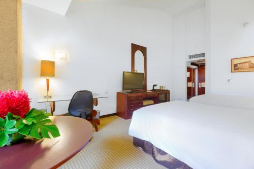 a hotel room with a bed and a desk and a television at Radisson San Jose-Costa Rica in San José