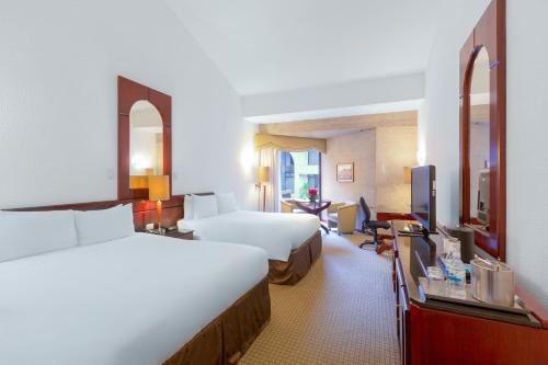 a hotel room with two beds and a television at Radisson San Jose-Costa Rica in San José