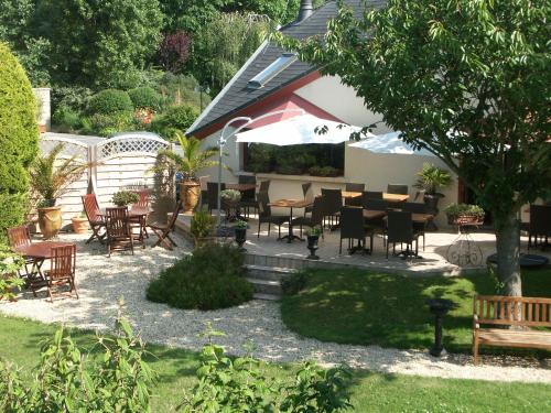 a patio with a bunch of chairs and tables at Hotel Nuit Et Jour - La Maison de Lucile in Cancale