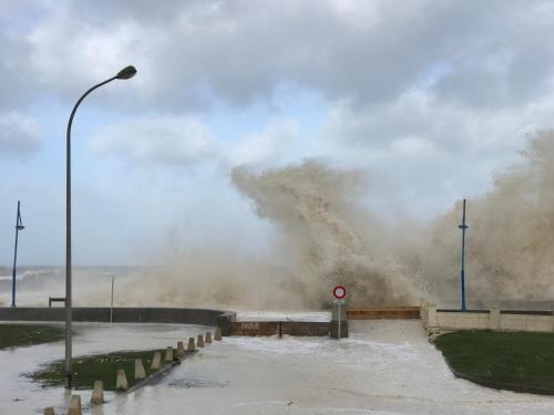 a large wave is crashing on a road at Chambres d'Hôtes Villa Mon Repos in Saint-Aubin-sur-Scie