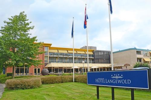 a blue sign in front of a building with flags at Fletcher Hotel-Restaurant Langewold in Roden